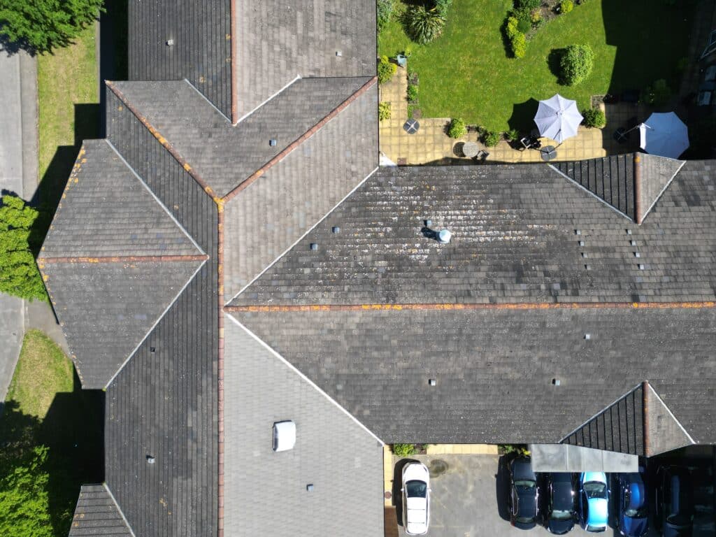 Aerial view of a complex roof architecture with cars