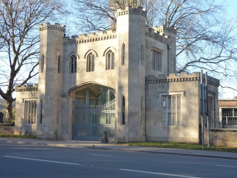 Historic stone gatehouse with arched gate on sunny day